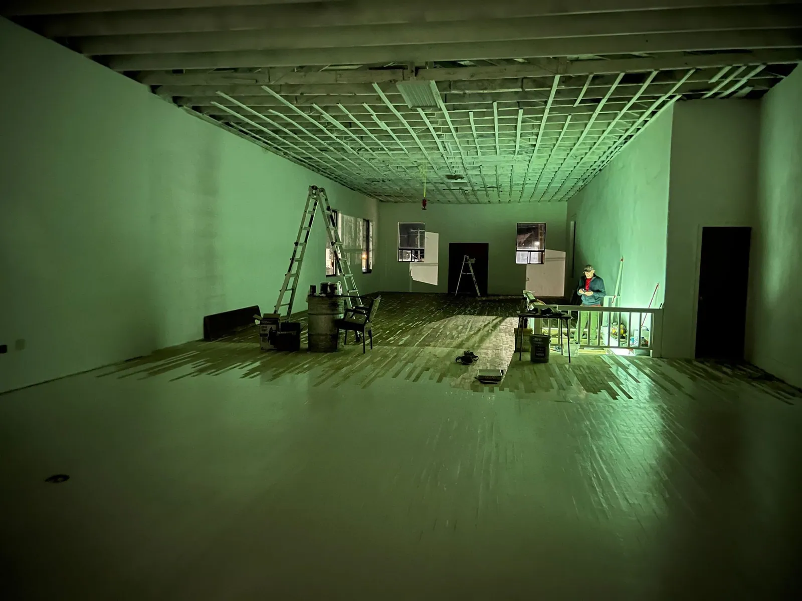A room is filled with an eerie green glow from the basement below.