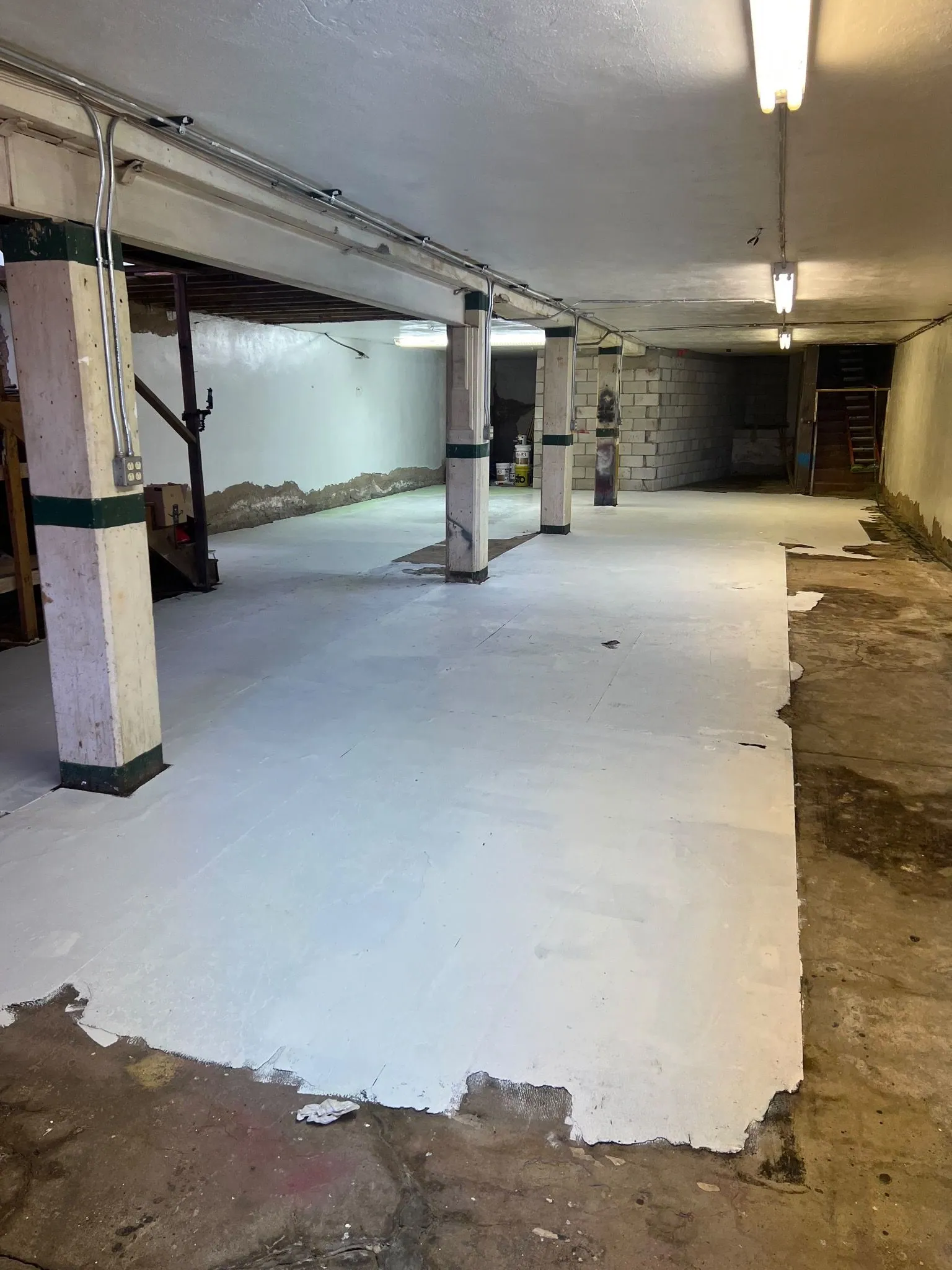 An empty basement floor gets a fresh coat of paint.
