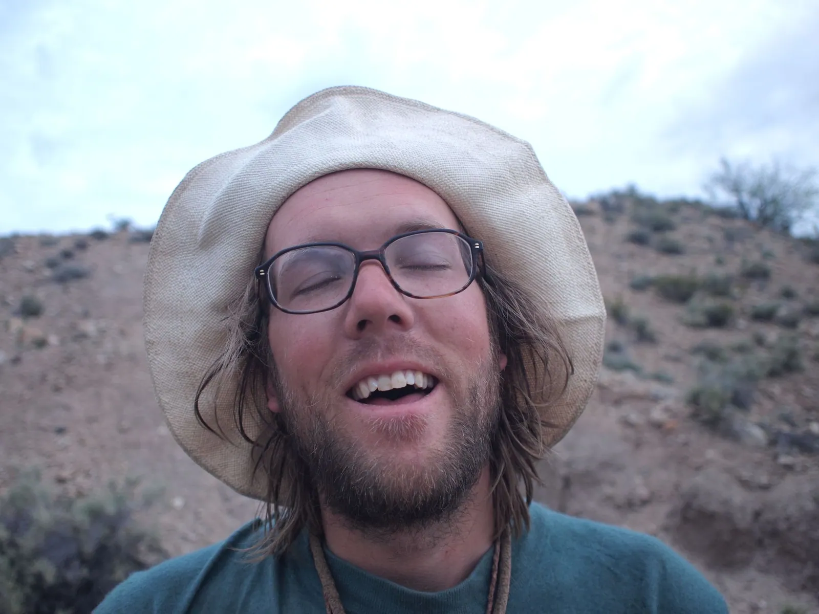 A man in a white hat, looking very happy